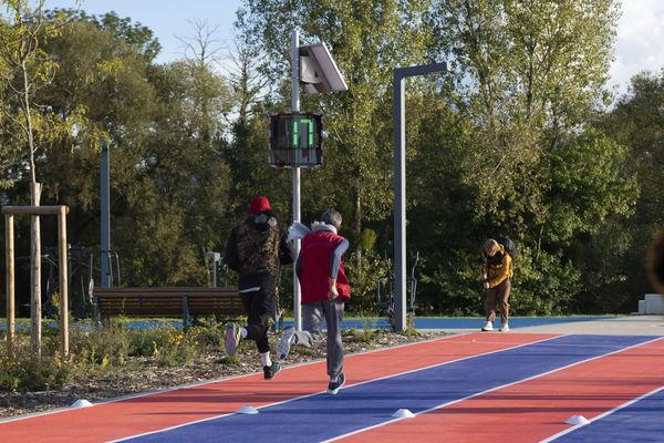 Two runners on the athletics track in Saint-Dizier, with an EVOLIS Vision radar speed sign displaying a speed of 17mph